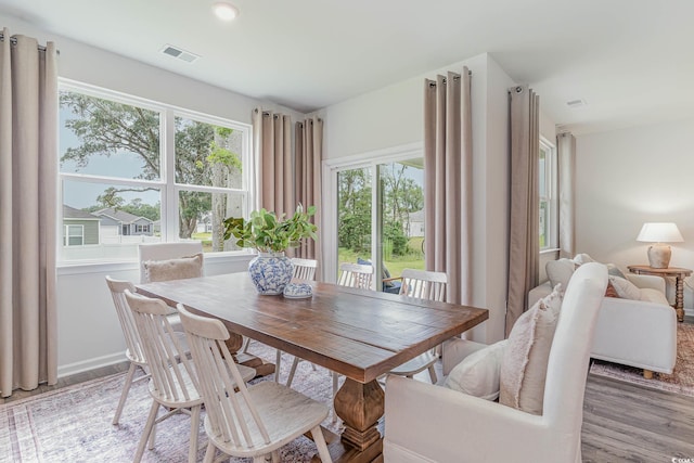 dining space featuring baseboards, light wood-style flooring, and visible vents