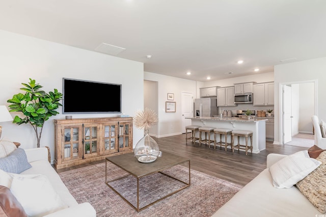 living room featuring baseboards, dark wood-style flooring, and recessed lighting