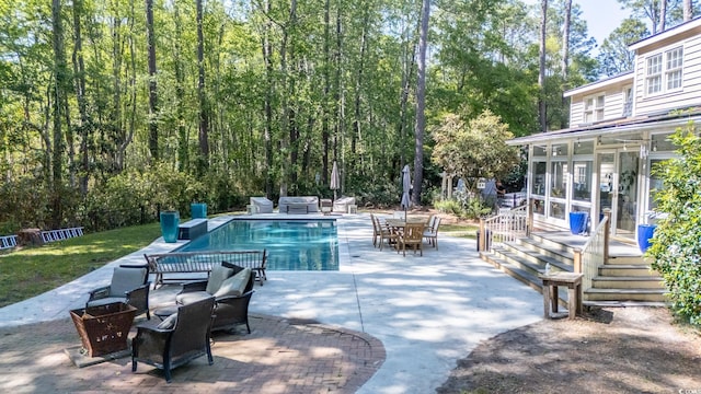 outdoor pool with a sunroom, a patio, and outdoor dining space