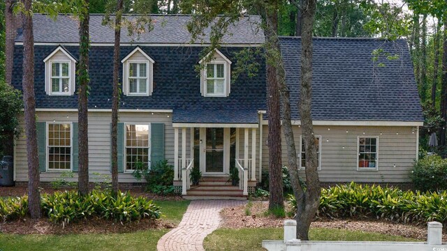 new england style home with a shingled roof