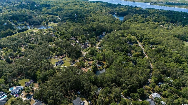 view of property location featuring a nearby body of water, a heavily wooded area, and a notable bridge
