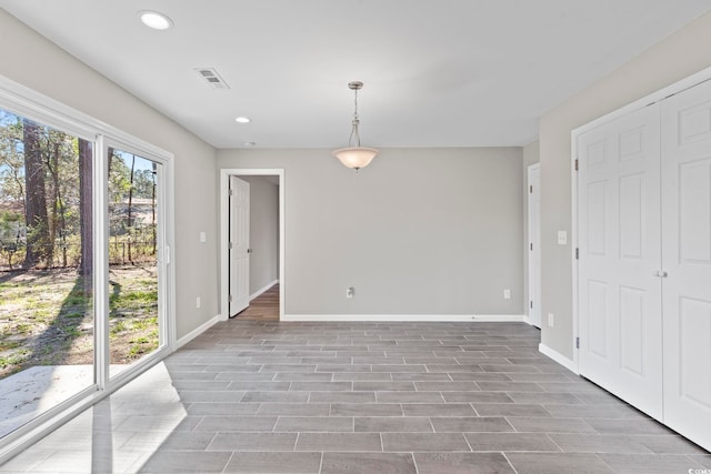 empty room featuring baseboards, recessed lighting, and wood finished floors