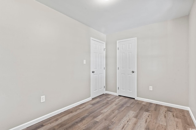 spare room featuring wood finished floors and baseboards