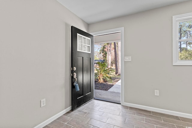 foyer entrance featuring baseboards and wood finish floors