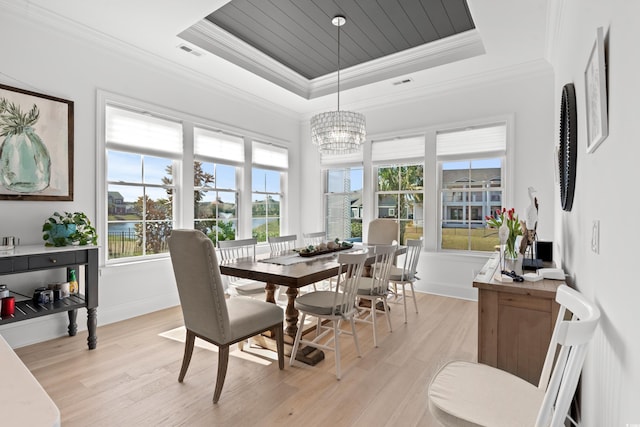 849 Crystal Water Way, Myrtle Beach, SC 29579 - dining room with a tray ceiling, light wood-type flooring, a water view, ornamental molding, and a chandelier