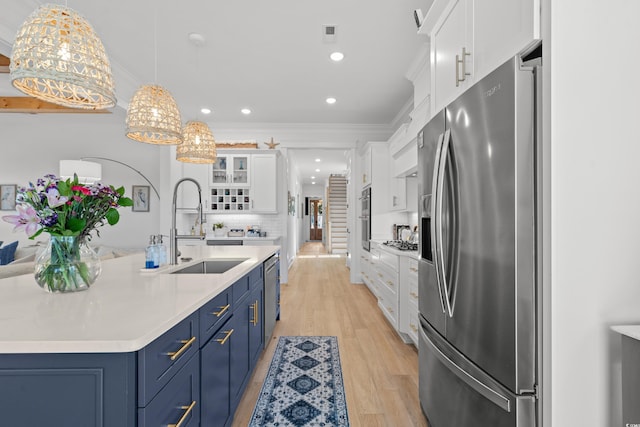 849 Crystal Water Way, Myrtle Beach, SC 29579 - kitchen with appliances with stainless steel finishes, blue cabinetry, white cabinets, a sink, and light countertops