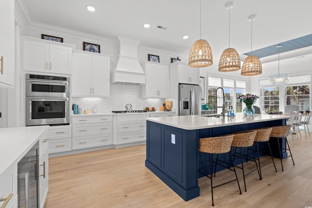 849 Crystal Water Way, Myrtle Beach, SC 29579 - kitchen featuring stainless steel appliances, a sink, premium range hood, a kitchen bar, and light countertops