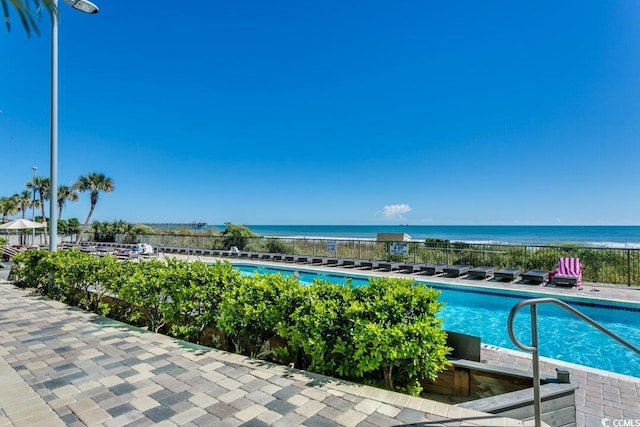 community pool featuring fence and a water view