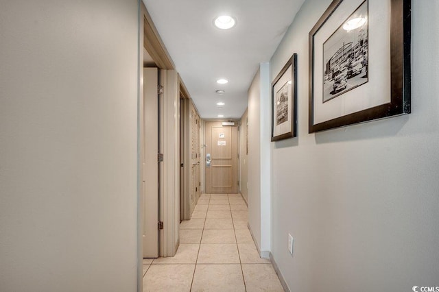 corridor with light tile patterned floors, recessed lighting, and baseboards