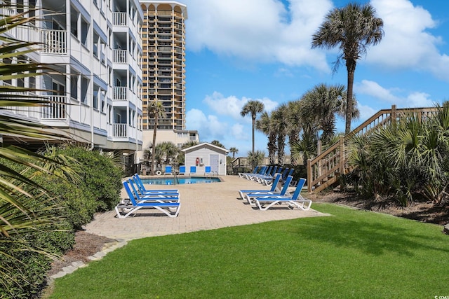 view of property's community with a yard, a patio, and a pool