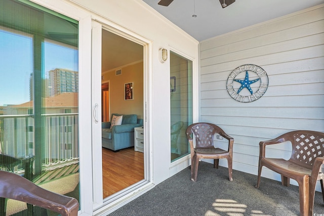 sunroom featuring visible vents, ornamental molding, carpet, and wood walls