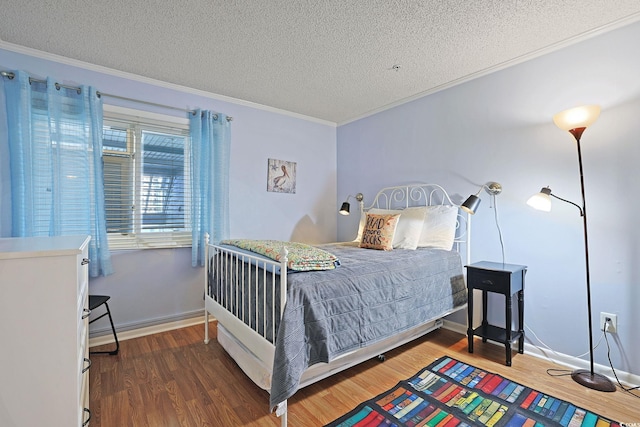 bedroom with ornamental molding, a textured ceiling, and wood finished floors