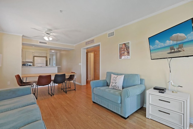 living room with ceiling fan, ornamental molding, and visible vents