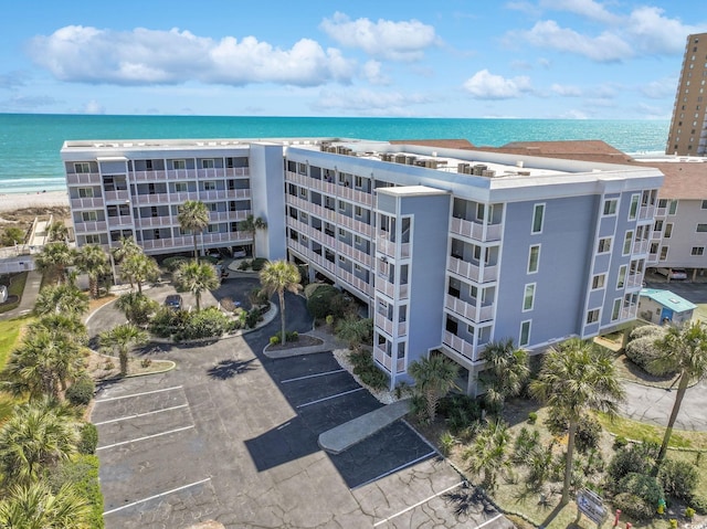 view of building exterior with a water view and uncovered parking
