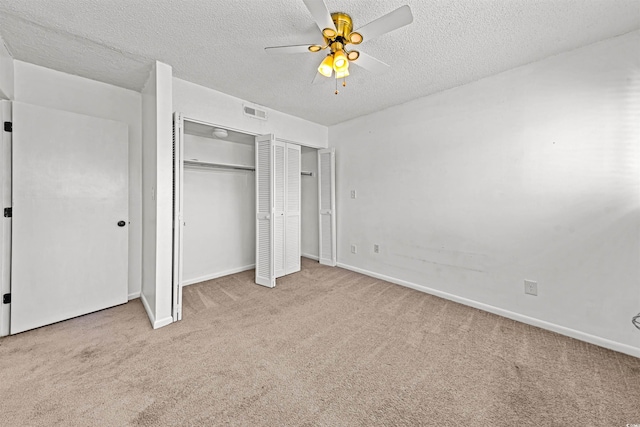 7300 Porcher Dr Unit 11, Myrtle Beach, SC 29572 - unfurnished bedroom featuring carpet flooring, baseboards, a textured ceiling, a ceiling fan, and multiple closets