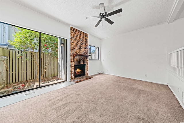 7300 Porcher Dr Unit 11, Myrtle Beach, SC 29572 - unfurnished living room featuring a textured ceiling, plenty of natural light, ceiling fan, a brick fireplace, and carpet floors