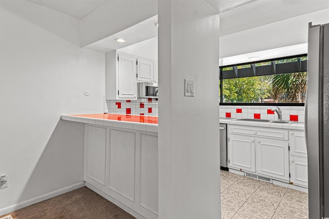 7300 Porcher Dr Unit 11, Myrtle Beach, SC 29572 - kitchen with tile countertops, decorative backsplash, stainless steel appliances, and a sink