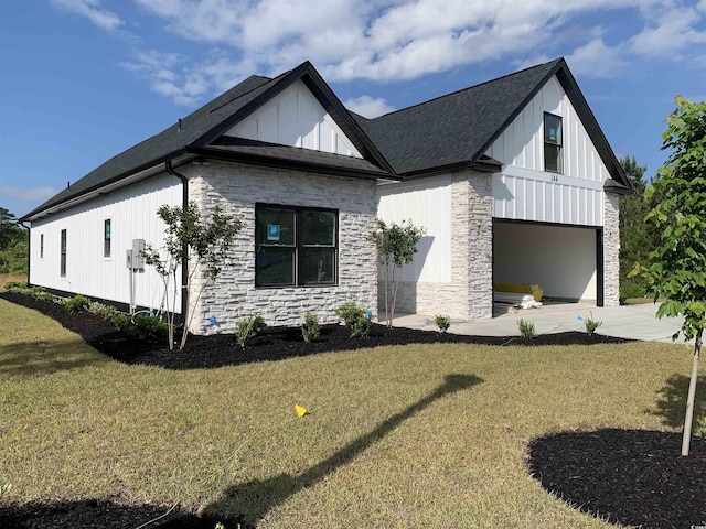 view of front of home with roof with shingles, stone siding, driveway, a front lawn, and board and batten siding