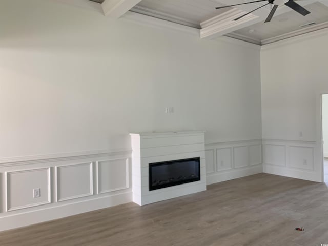 144 Sago Palm Dr, Myrtle Beach, SC 29579 - unfurnished living room featuring a ceiling fan, a glass covered fireplace, wood finished floors, a wainscoted wall, and crown molding