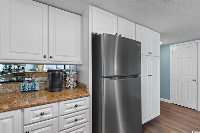 501 S Ocean Blvd Unit 1006, North Myrtle Beach, SC 29582 - kitchen featuring freestanding refrigerator, dark wood finished floors, white cabinetry, stone countertops, and a textured ceiling