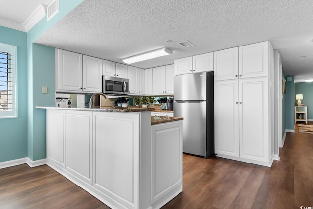 501 S Ocean Blvd Unit 1006, North Myrtle Beach, SC 29582 - kitchen with stainless steel appliances, dark wood-type flooring, a peninsula, white cabinets, and baseboards