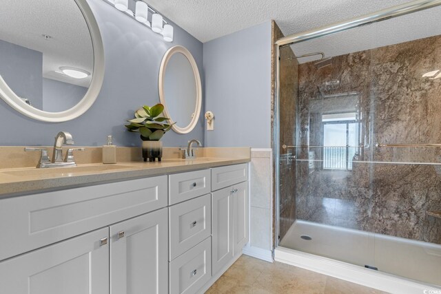 501 S Ocean Blvd Unit 1006, North Myrtle Beach, SC 29582 - bathroom featuring a textured ceiling, a shower stall, double vanity, and tile patterned flooring