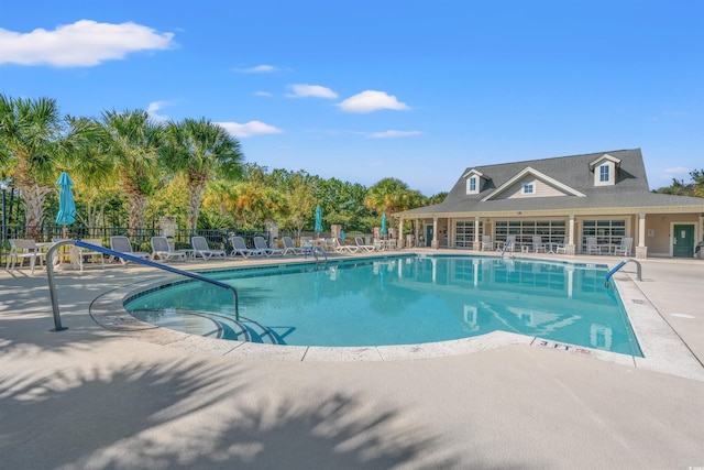 community pool with fence and a patio area
