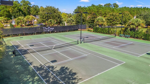 view of tennis court featuring fence and community basketball court