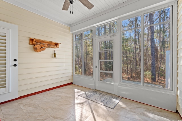 unfurnished sunroom featuring a ceiling fan