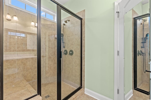 full bathroom with a shower stall, tile patterned floors, and baseboards