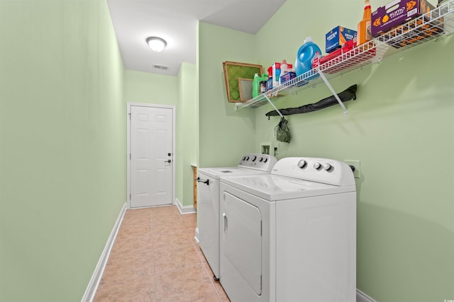 laundry area with washer and dryer, light tile patterned floors, and baseboards