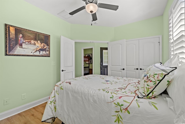 bedroom featuring wood finished floors, a closet, baseboards, and ceiling fan
