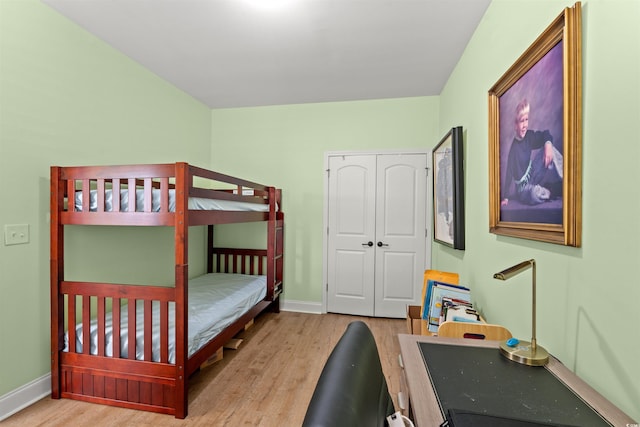 bedroom featuring wood finished floors, baseboards, and a closet
