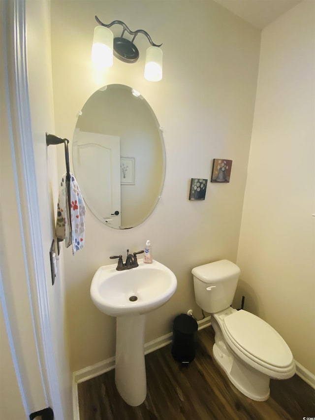 bathroom with wood finished floors, toilet, and baseboards
