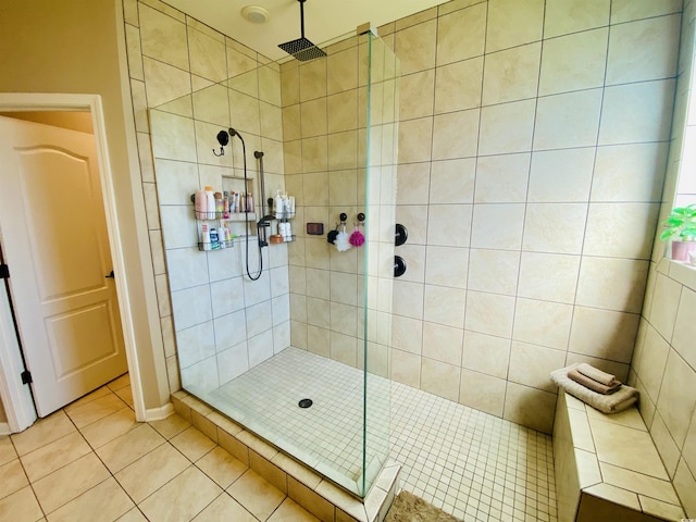 full bath featuring tile patterned flooring, baseboards, and a walk in shower