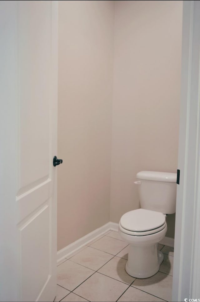 bathroom featuring tile patterned floors, baseboards, and toilet