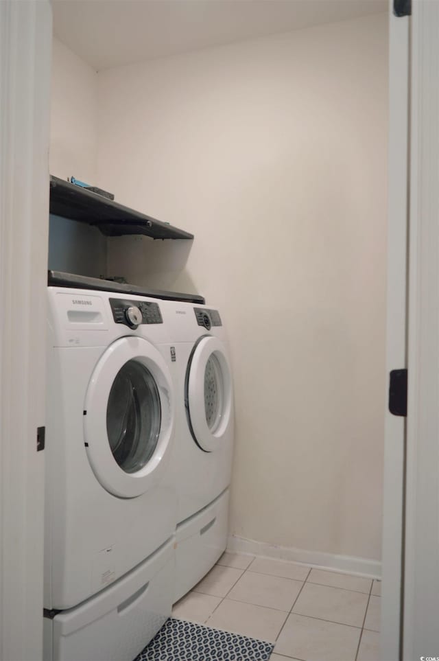 laundry room with separate washer and dryer, baseboards, laundry area, and light tile patterned floors