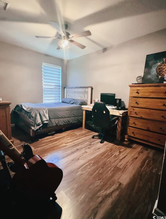 bedroom with visible vents, a ceiling fan, and wood finished floors