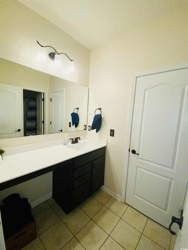 bathroom featuring baseboards, tile patterned flooring, and vanity