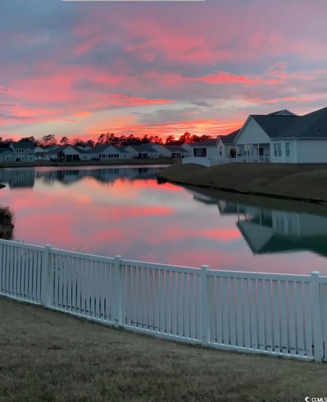 property view of water with a fenced backyard and a residential view