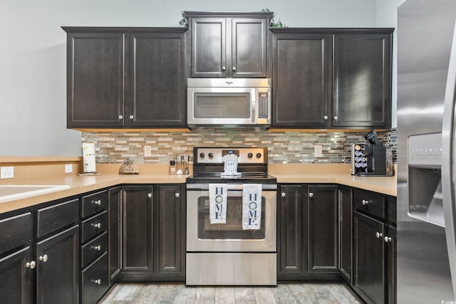 6253 Catalina Dr Unit 713, North Myrtle Beach, SC 29582 - kitchen with appliances with stainless steel finishes, light countertops, tasteful backsplash, and light wood-type flooring