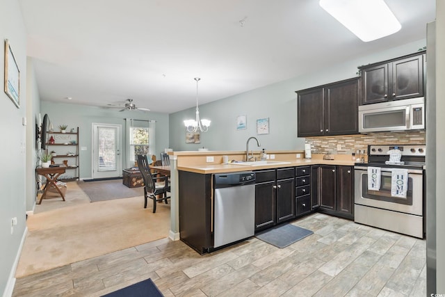 6253 Catalina Dr Unit 713, North Myrtle Beach, SC 29582 - kitchen featuring appliances with stainless steel finishes, open floor plan, a peninsula, a sink, and wood tiled floors