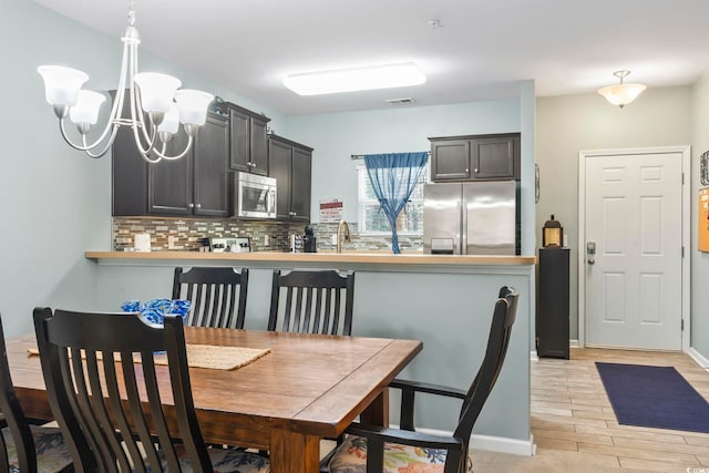 6253 Catalina Dr Unit 713, North Myrtle Beach, SC 29582 - dining space featuring light wood-style floors, a chandelier, and baseboards