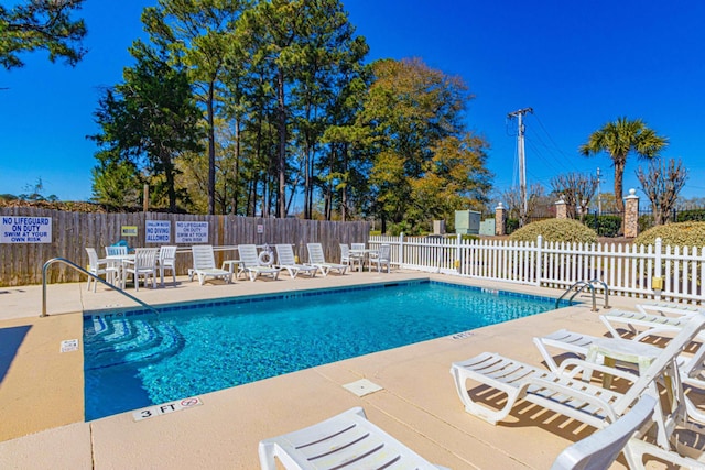 pool with fence and a patio