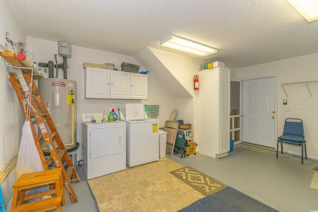 clothes washing area featuring water heater, separate washer and dryer, cabinet space, and a textured ceiling
