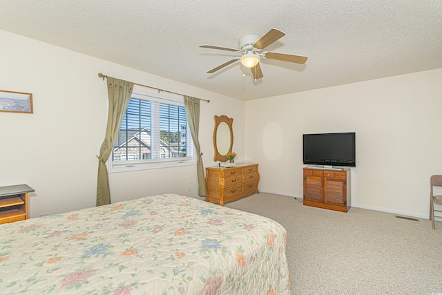 bedroom featuring baseboards, a ceiling fan, carpet flooring, and a textured ceiling