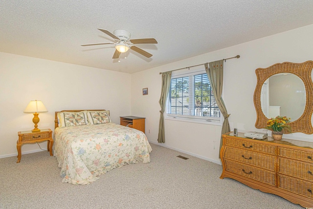 carpeted bedroom with visible vents, a textured ceiling, baseboards, and a ceiling fan