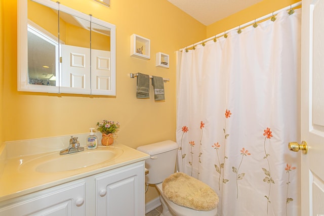 bathroom with vanity, toilet, and curtained shower