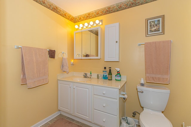 bathroom featuring vanity, baseboards, tile patterned flooring, and toilet