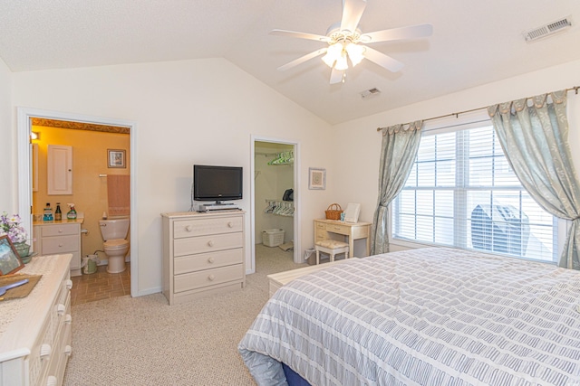 bedroom featuring light colored carpet, baseboards, visible vents, and lofted ceiling